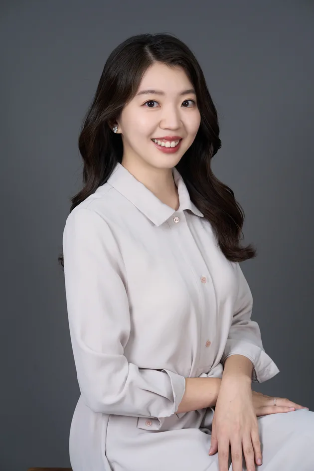 形象照作品：穿淺色襯衫、坐著微笑的女生