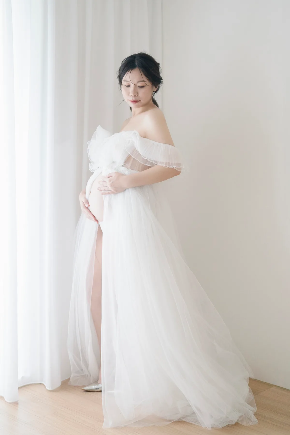 作品:穿白紗、手放在肚子上的準媽媽