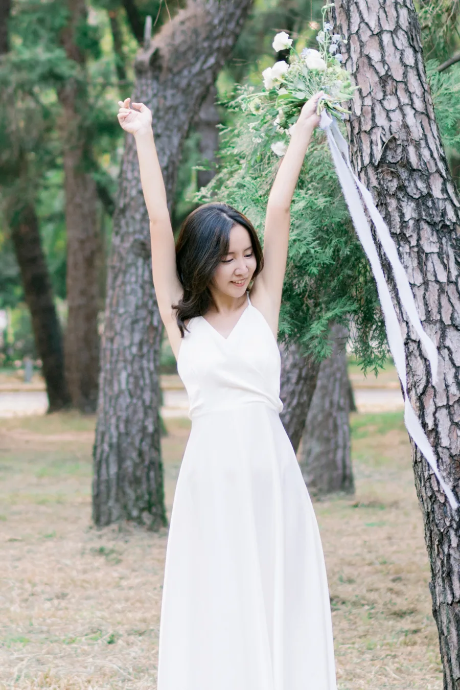 作品:在樹林裡舉起雙手的白洋裝女生